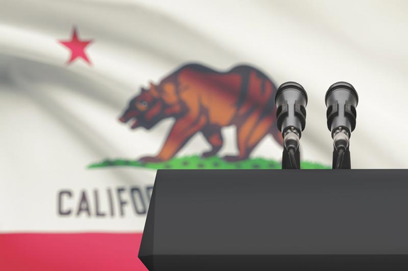 Photo of podium in front of California flag